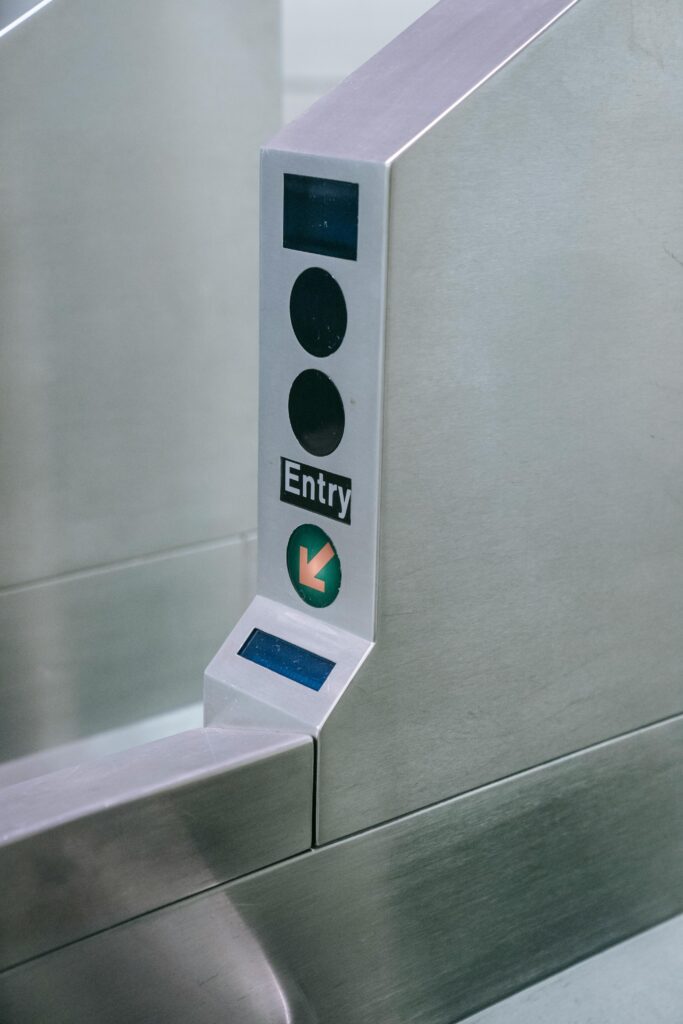 pexels-photo-8554382-8554382 Close-up of a metro station entry gate with scanner and directional arrow.